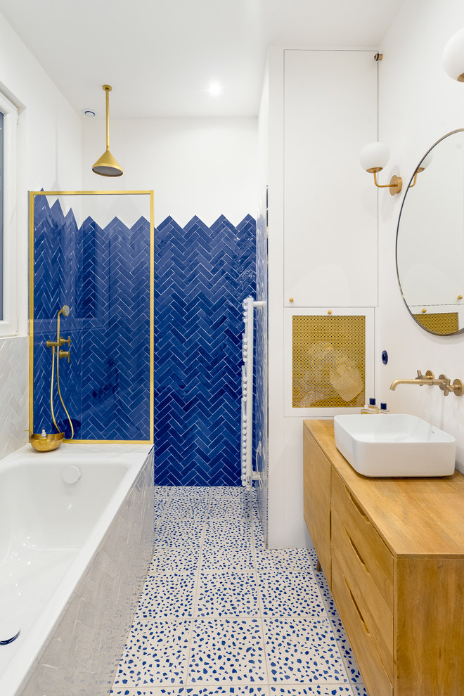 Пример оригинального дизайна: главная ванная комната среднего размера в скандинавском стиле с светлыми деревянными фасадами, синей плиткой, белыми стенами, настольной раковиной, столешницей из дерева, разноцветным полом, открытым душем, полновстраиваемой ванной, душем без бортиков, терракотовой плиткой, полом из терраццо, коричневой столешницей, зеркалом с подсветкой и плоскими фасадами