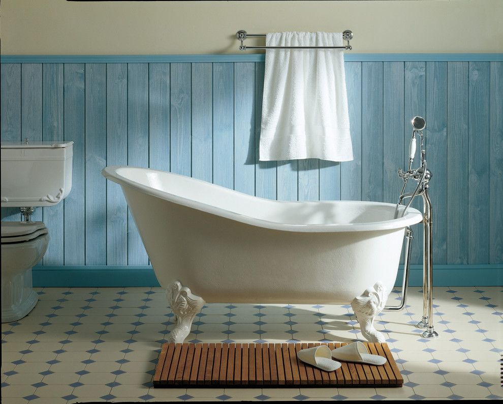 Bild på ett vintage badrum, med ett badkar med tassar, en dusch/badkar-kombination, vit kakel, blå kakel, flerfärgade väggar och flerfärgat golv