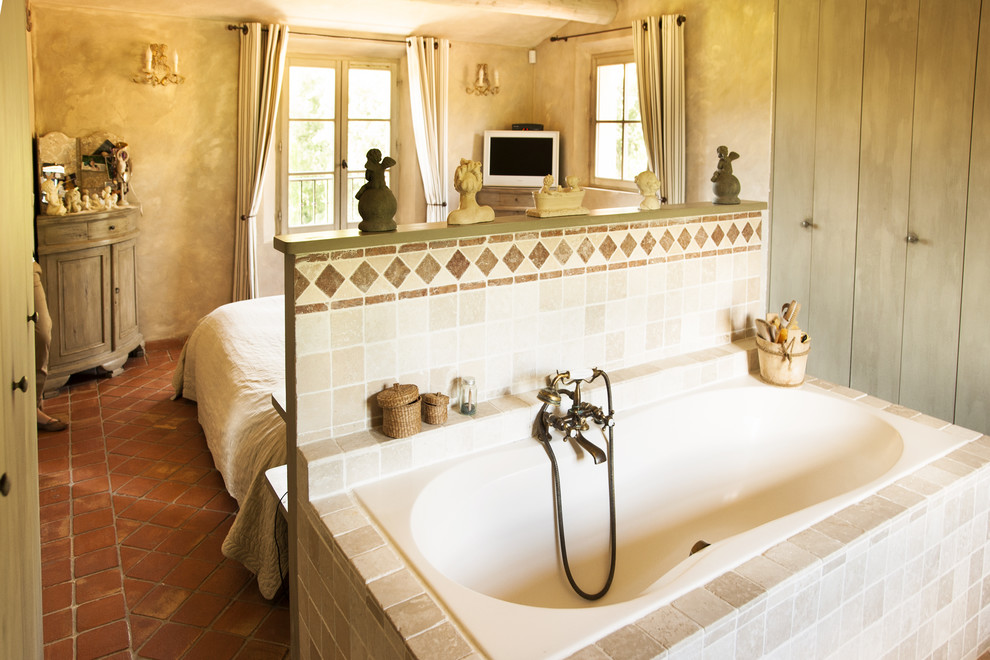 Imagen de cuarto de baño principal mediterráneo de tamaño medio con bañera encastrada sin remate, baldosas y/o azulejos beige y suelo de baldosas de terracota