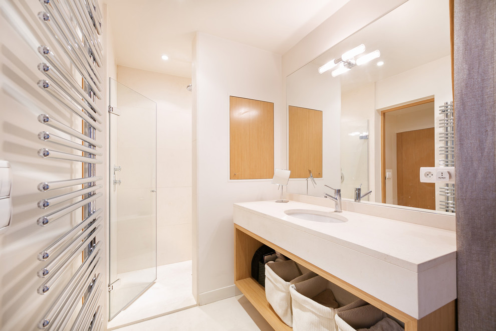 Ejemplo de cuarto de baño principal contemporáneo de tamaño medio con lavabo bajoencimera, puertas de armario de madera clara, encimera de piedra caliza, armarios abiertos, ducha empotrada y paredes blancas