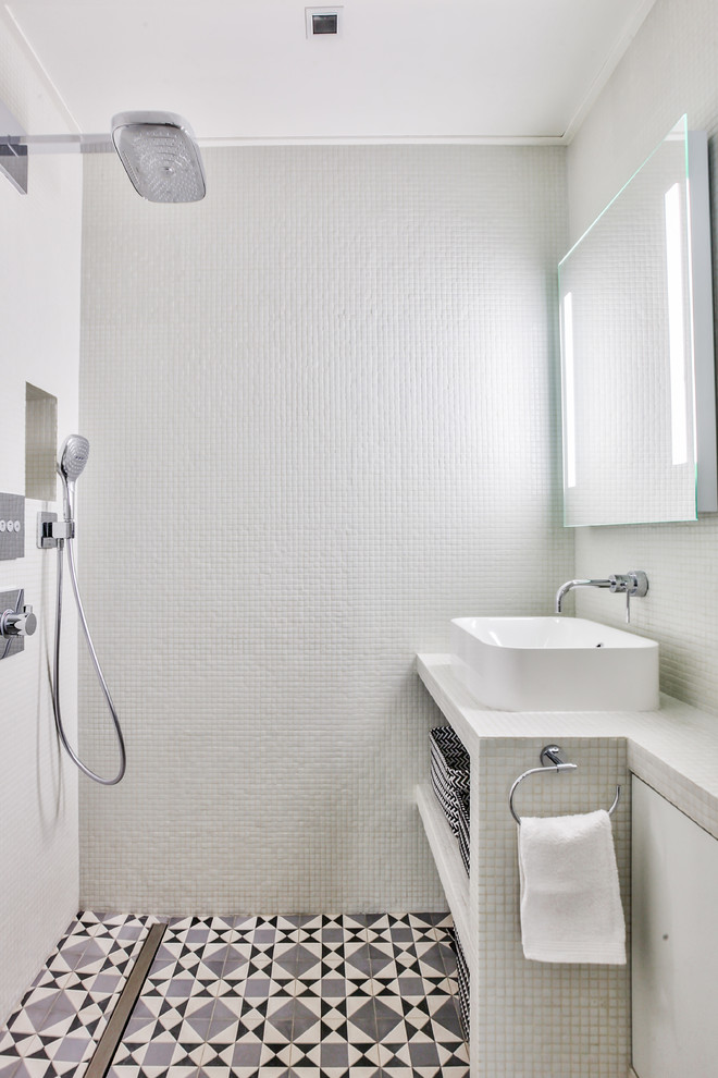 Idéer för små industriella vitt badrum med dusch, med vit kakel, vita väggar, kaklad bänkskiva, grått golv, med dusch som är öppen, vita skåp, en kantlös dusch, en vägghängd toalettstol, mosaik, cementgolv och ett fristående handfat