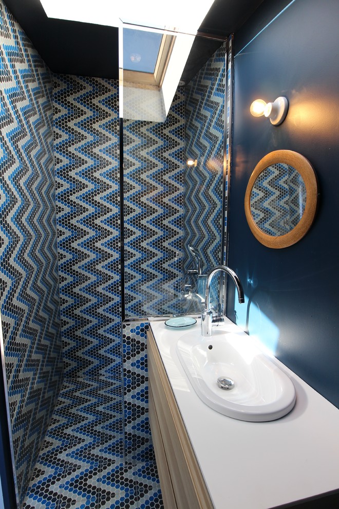 Exempel på ett litet modernt badrum med dusch, med skåp i ljust trä, en dusch i en alkov, blå väggar och med dusch som är öppen