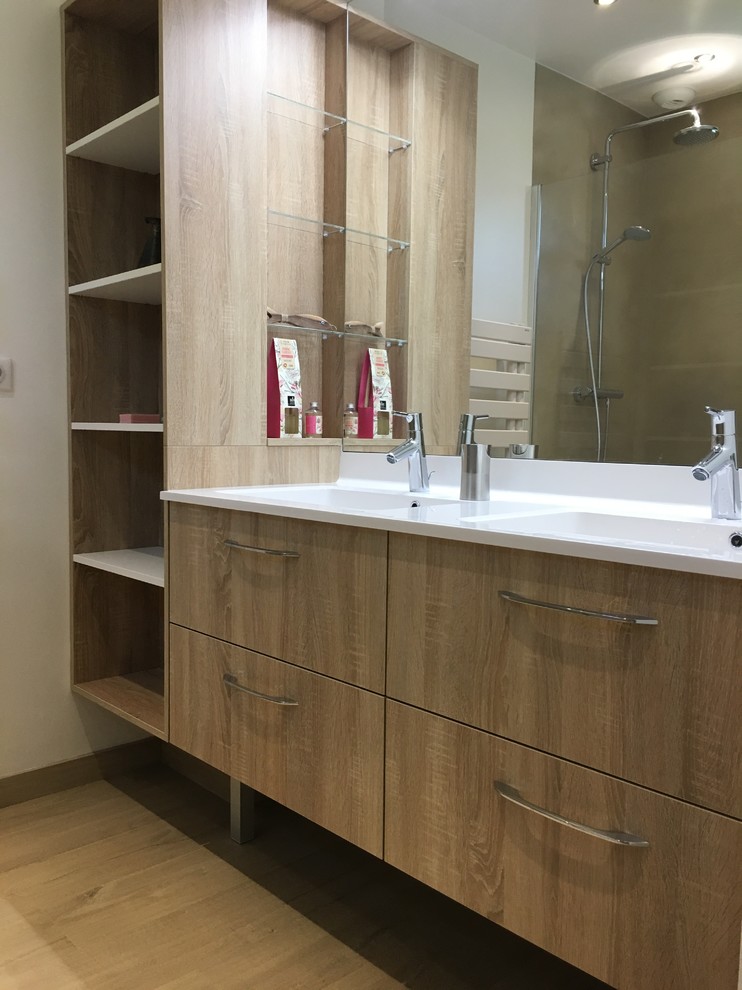 Bild på ett mellanstort funkis en-suite badrum, med luckor med profilerade fronter, beige skåp, en kantlös dusch, cementkakel, vita väggar, ljust trägolv, ett integrerad handfat, bänkskiva i akrylsten, beiget golv och dusch med gångjärnsdörr