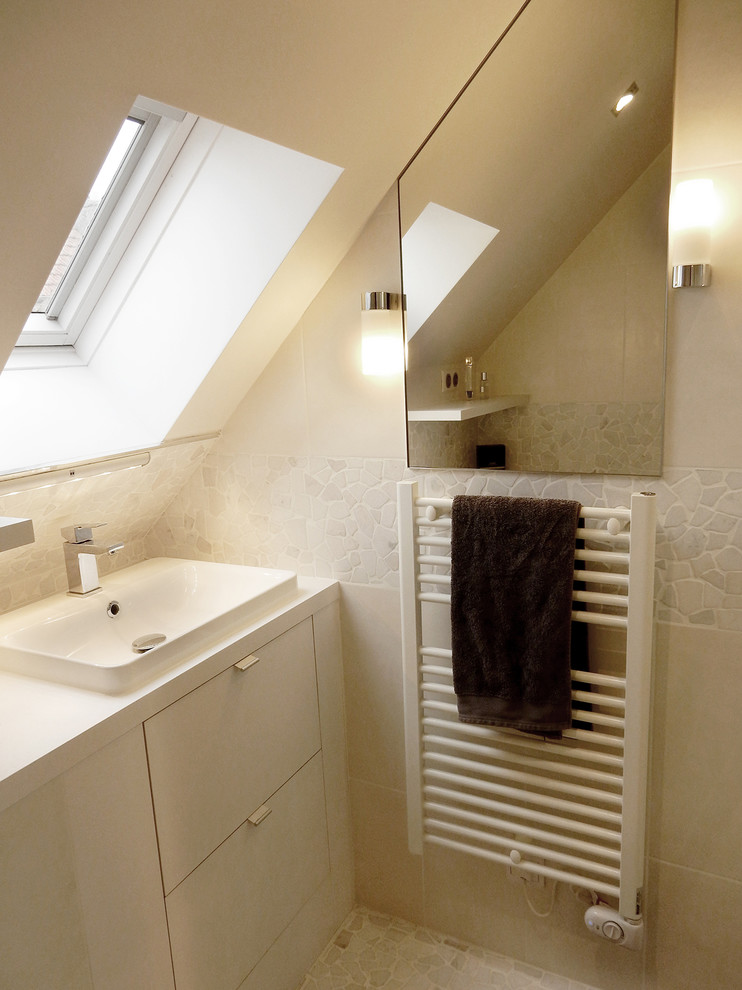 Cette photo montre une petite salle d'eau tendance avec un carrelage blanc, des carreaux de céramique, un mur blanc, un sol en galet, un lavabo encastré et un plan de toilette en stratifié.