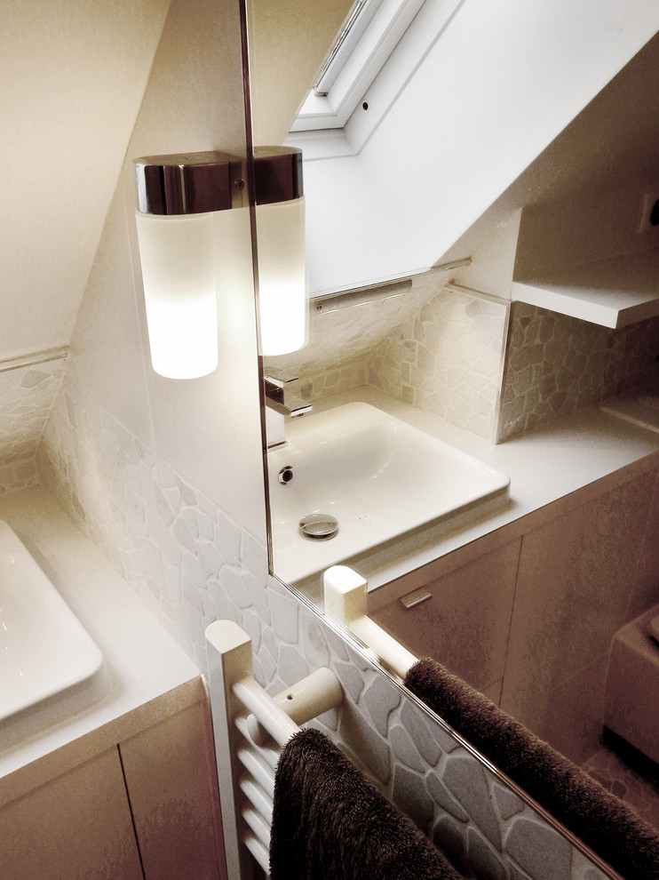 Exemple d'une petite salle d'eau tendance avec un placard à porte affleurante, des portes de placard blanches, un carrelage blanc, des carreaux de céramique, un mur blanc, un sol en galet, un plan vasque et un plan de toilette en stratifié.