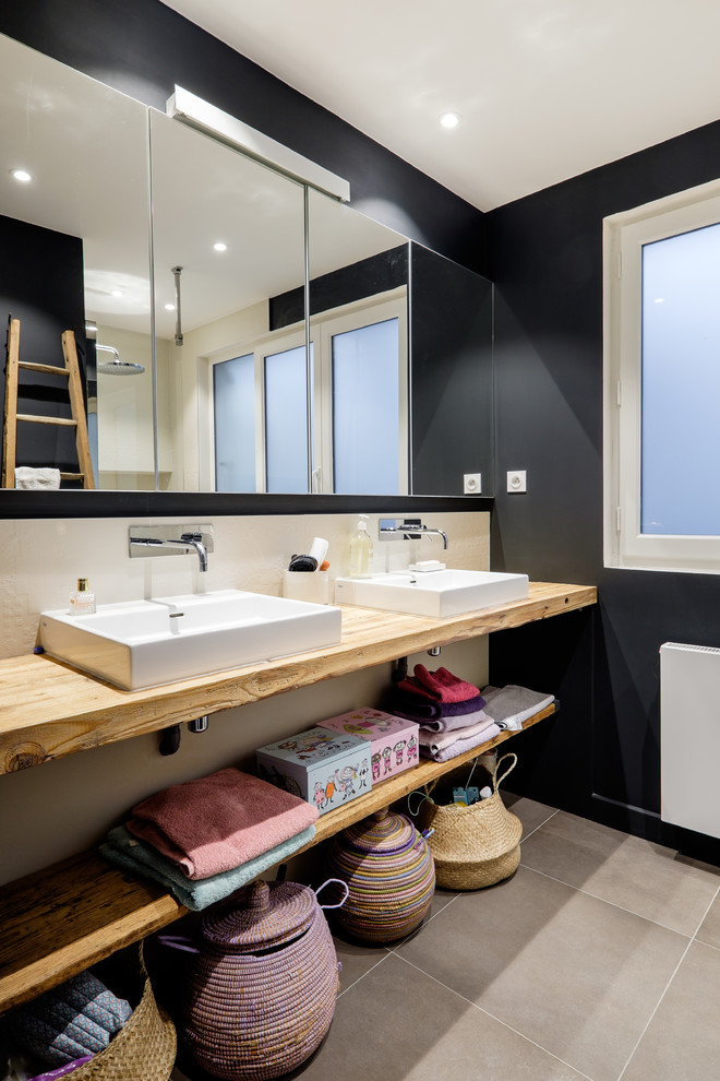 Aménagement d'une salle de bain principale contemporaine avec un mur noir, une grande vasque, un plan de toilette en bois et un sol gris.