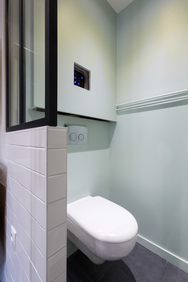 Idéer för att renovera ett mellanstort minimalistiskt vit vitt en-suite badrum, med släta luckor, skåp i mellenmörkt trä, en dusch i en alkov, en vägghängd toalettstol, vit kakel, porslinskakel, vita väggar, klinkergolv i keramik, ett konsol handfat, bänkskiva i akrylsten, grått golv och dusch med gångjärnsdörr