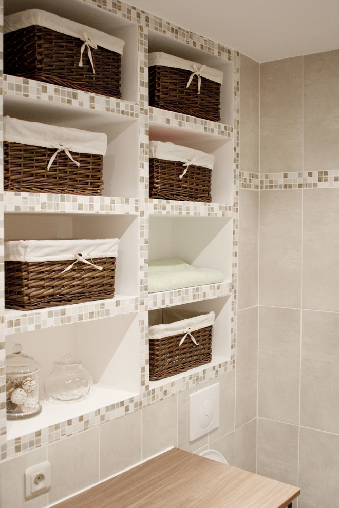 Mittelgroßes Modernes Duschbad mit offenen Schränken, Unterbauwanne, Wandtoilette, beigen Fliesen, Einbauwaschbecken und Laminat-Waschtisch in Paris