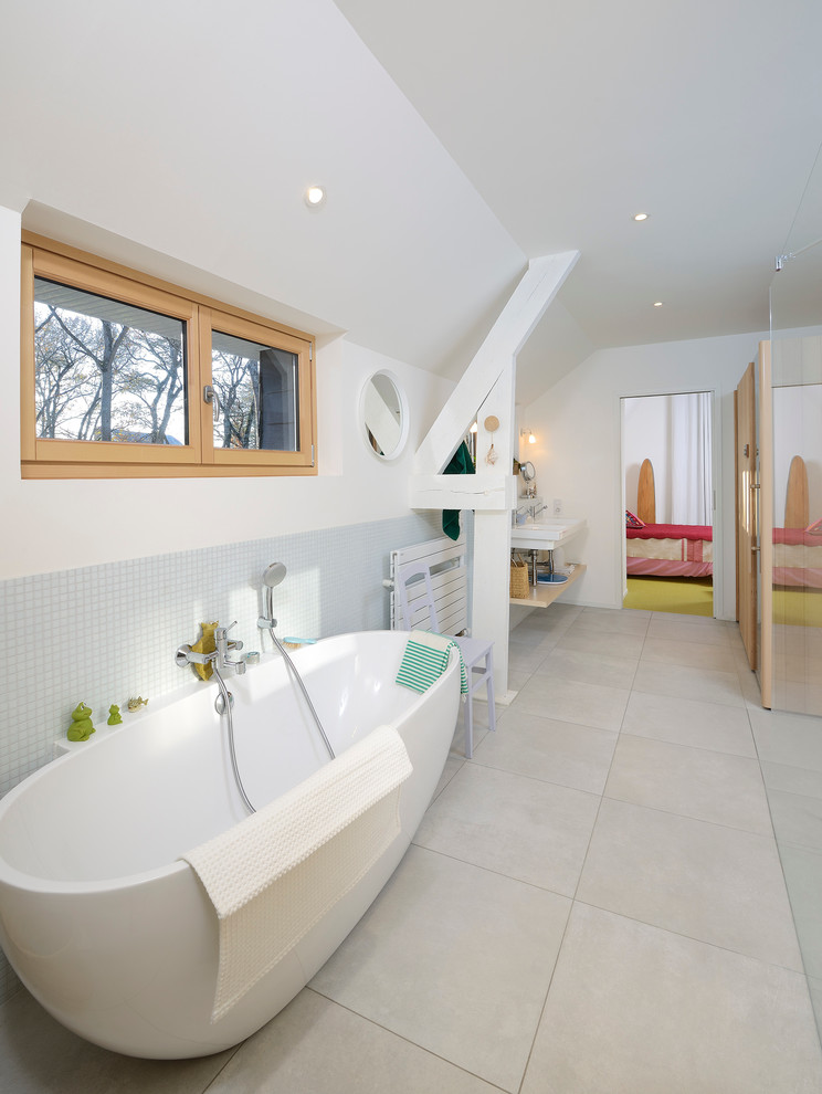 Großes Modernes Badezimmer mit Kassettenfronten, Einbaubadewanne, Glasfliesen, Keramikboden und Waschtischkonsole in Angers