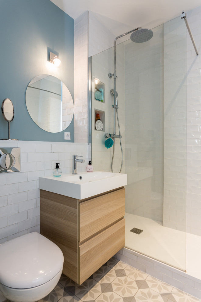 Idéer för ett litet modernt vit en-suite badrum, med porslinskakel, vita väggar, släta luckor, skåp i ljust trä, en öppen dusch, en vägghängd toalettstol, vit kakel, cementgolv, ett konsol handfat, bänkskiva i akrylsten, flerfärgat golv och med dusch som är öppen