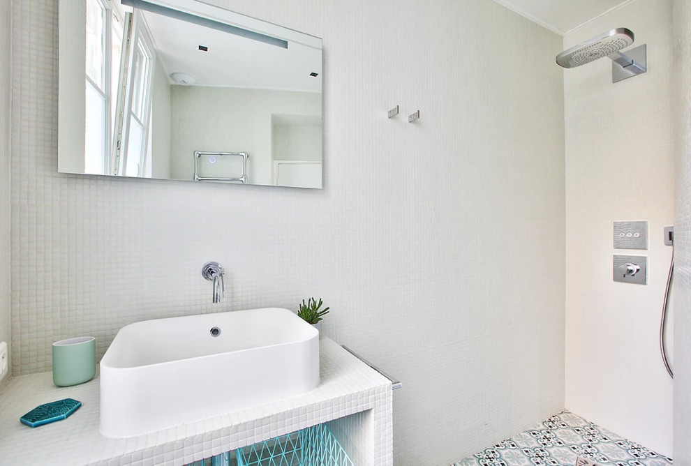 Aménagement d'une petite salle d'eau contemporaine avec un carrelage blanc, mosaïque, un lavabo posé, un sol bleu, des portes de placard blanches, une douche à l'italienne, WC suspendus, un mur blanc, carreaux de ciment au sol et aucune cabine.