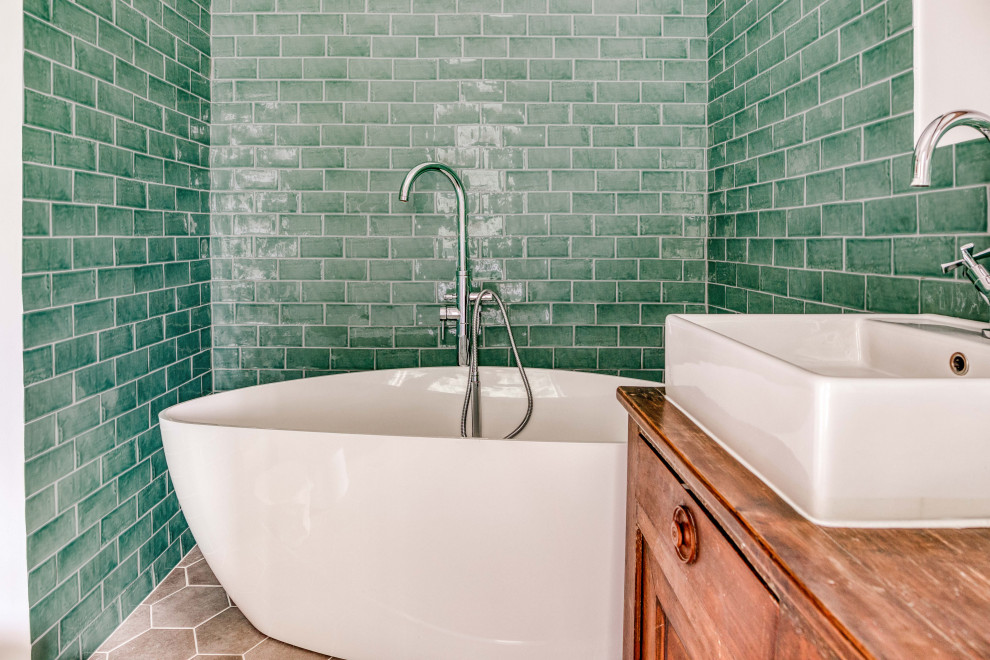 Inspiration för ett mellanstort vintage brun brunt en-suite badrum, med ett platsbyggt badkar, grön kakel, klinkergolv i keramik, träbänkskiva, grått golv, luckor med profilerade fronter, skåp i mörkt trä, en dusch/badkar-kombination, en toalettstol med hel cisternkåpa, keramikplattor, gröna väggar, ett nedsänkt handfat och med dusch som är öppen