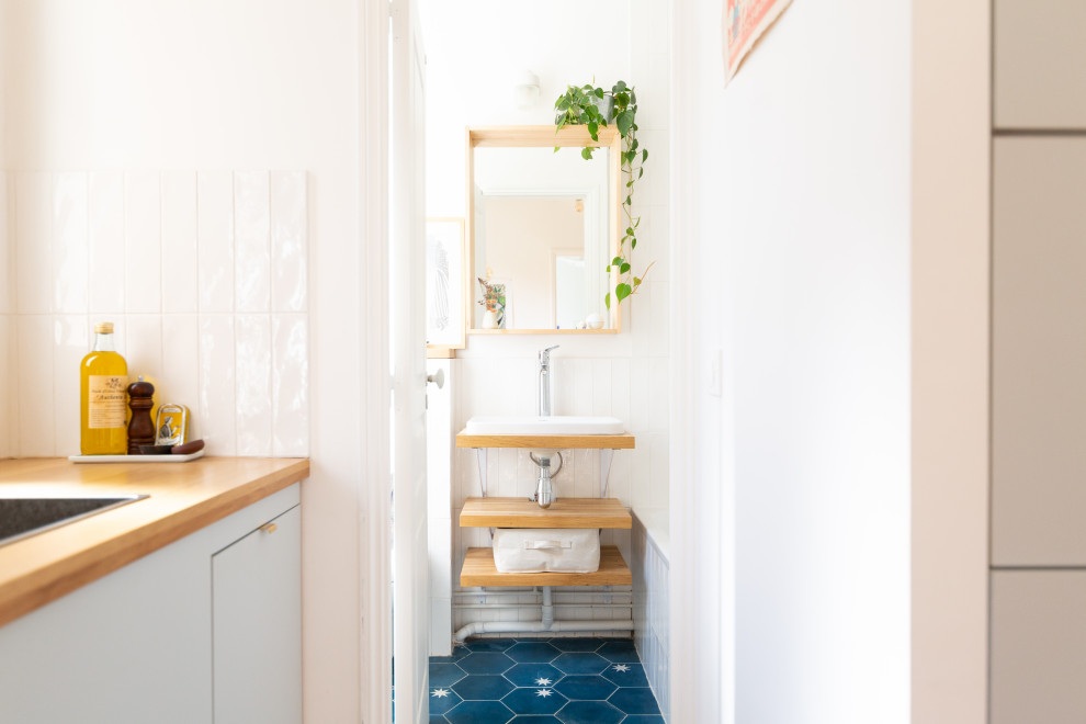 Idées déco pour une petite salle de bain principale contemporaine avec un carrelage blanc, un mur blanc, carreaux de ciment au sol, un sol bleu, meuble simple vasque, une baignoire encastrée, un lavabo posé, un plan de toilette en bois et un plan de toilette marron.