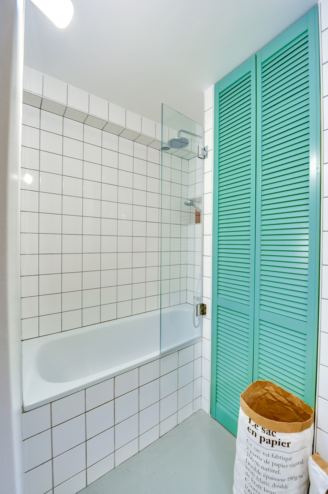 Kleines Mid-Century Badezimmer En Suite mit Lamellenschränken, grünen Schränken, weißen Fliesen, Keramikfliesen, weißer Wandfarbe, gebeiztem Holzboden, Waschtisch aus Holz, Unterbauwanne und Einbauwaschbecken in Paris