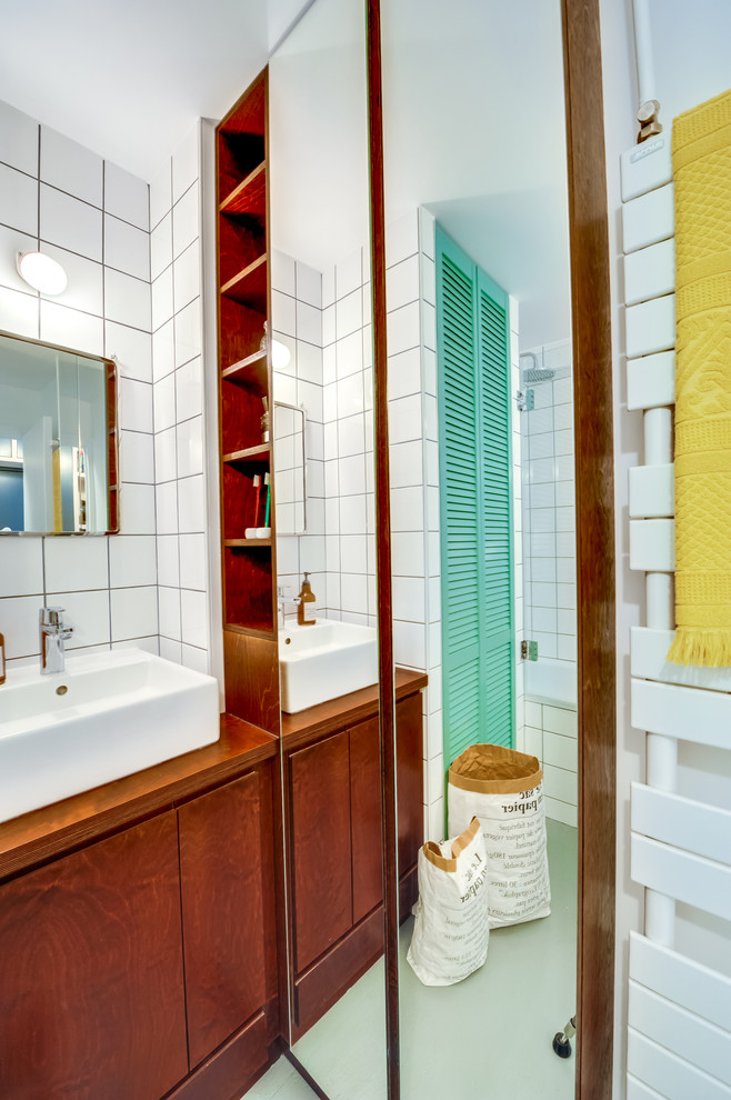 Kleines Retro Badezimmer En Suite mit weißen Fliesen, Keramikfliesen, weißer Wandfarbe, gebeiztem Holzboden, Waschtisch aus Holz, flächenbündigen Schrankfronten, dunklen Holzschränken, Unterbauwanne und Einbauwaschbecken in Paris