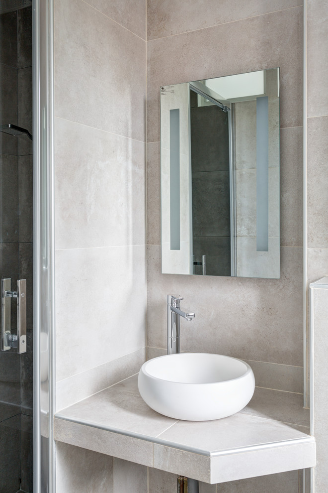 Small contemporary ensuite bathroom in Paris with open cabinets, grey cabinets, an alcove shower, grey tiles, ceramic tiles, grey walls, ceramic flooring, a vessel sink, tiled worktops, grey floors, a hinged door and grey worktops.