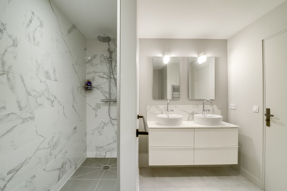 Cette photo montre une salle de bain principale tendance avec une douche à l'italienne, un carrelage blanc, un carrelage de pierre, un mur blanc, un lavabo posé et un sol en carrelage de céramique.