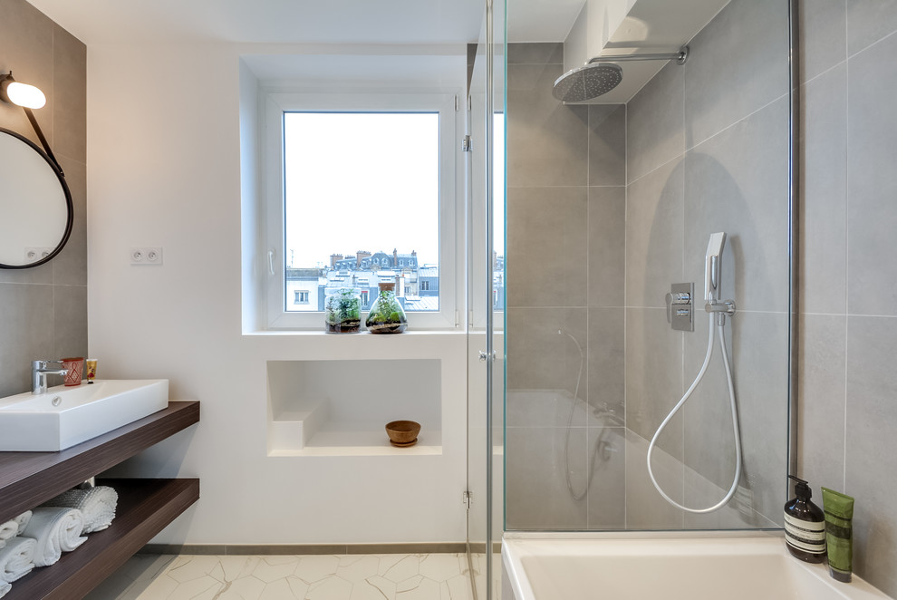 Immagine di una stanza da bagno padronale minimal di medie dimensioni con vasca sottopiano, doccia a filo pavimento, piastrelle grigie, piastrelle in ceramica, pareti grigie, pavimento in marmo, lavabo da incasso e top in legno