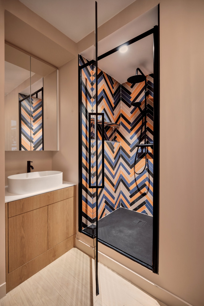 Example of a small trendy 3/4 multicolored tile and wood-look tile light wood floor, brown floor and single-sink alcove shower design in Paris with beaded inset cabinets, light wood cabinets, pink walls, a console sink, solid surface countertops, a hinged shower door, white countertops, a niche and a freestanding vanity