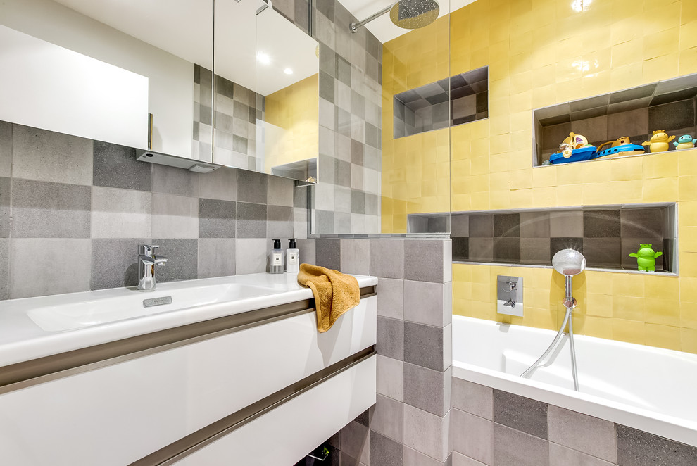 На фото: маленькая главная ванная комната в современном стиле с полновстраиваемой ванной, душем над ванной, желтой плиткой, терракотовой плиткой, серыми стенами, фасадами с декоративным кантом, белыми фасадами, полом из керамической плитки и консольной раковиной для на участке и в саду