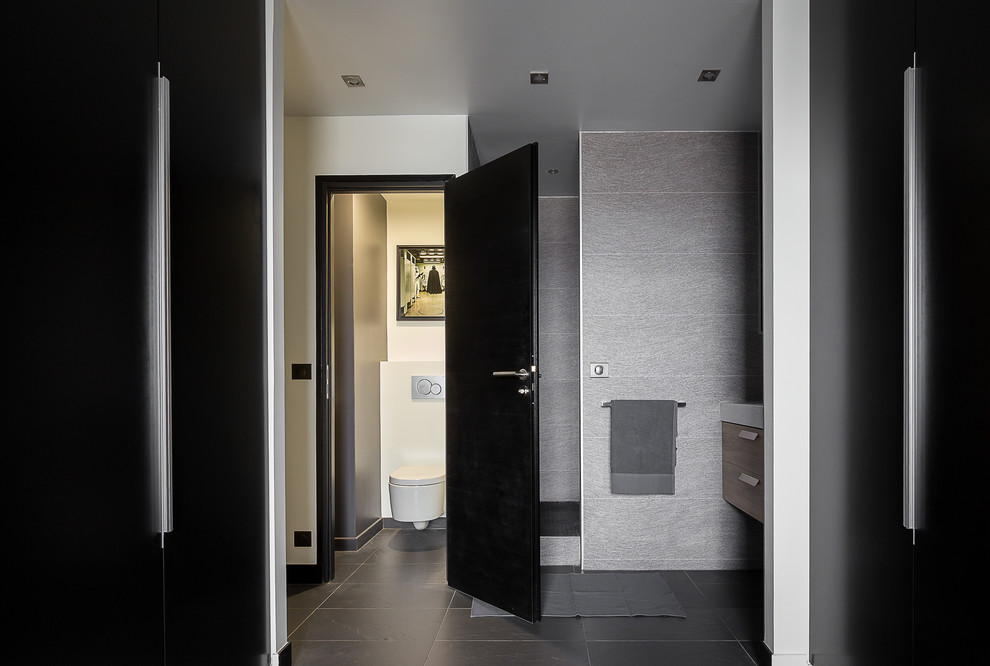 Idee per una stanza da bagno con doccia contemporanea di medie dimensioni con ante a filo, doccia a filo pavimento, WC sospeso, piastrelle grigie, pareti bianche, pavimento in ardesia e lavabo sospeso