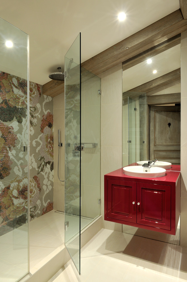 Aménagement d'une salle de bain contemporaine avec un lavabo posé, un placard avec porte à panneau encastré, des portes de placard rouges, un carrelage multicolore, mosaïque et un mur beige.