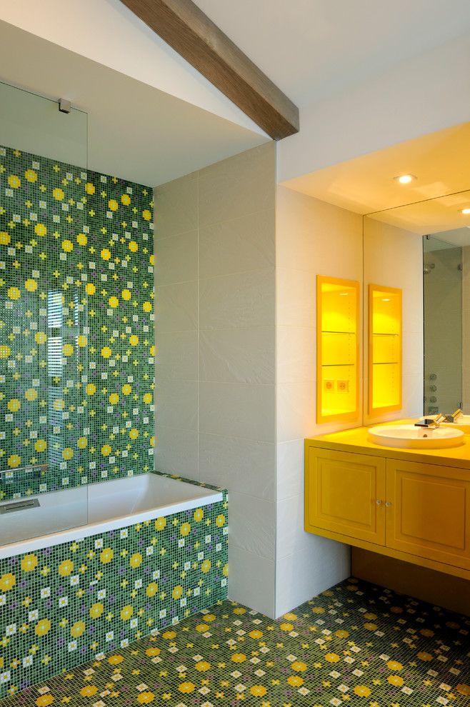 Cette image montre une salle de bain principale design de taille moyenne avec un placard avec porte à panneau encastré, des portes de placard jaunes, une baignoire posée, un combiné douche/baignoire, un carrelage multicolore, mosaïque, un mur blanc, un sol en carrelage de terre cuite et un lavabo encastré.