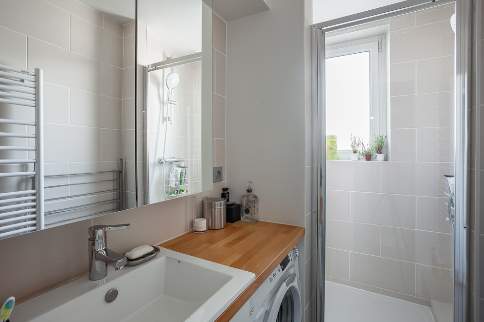 Modern inredning av ett litet badrum med dusch, med träbänkskiva, beige kakel, keramikplattor, en dusch i en alkov, ett fristående handfat, beige väggar och skiffergolv