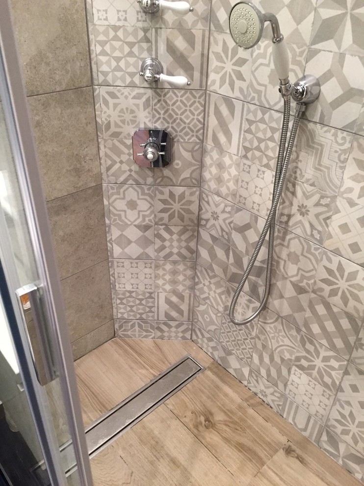 Esempio di una piccola stanza da bagno con doccia moderna con doccia a filo pavimento, piastrelle grigie, piastrelle di cemento, pareti grigie, pavimento con piastrelle in ceramica, lavabo da incasso, pavimento marrone e porta doccia scorrevole