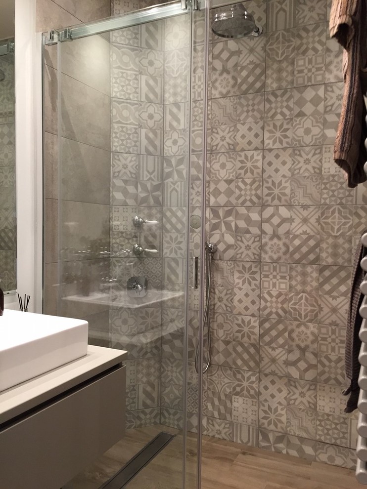 Exemple d'une petite salle d'eau rétro avec une douche à l'italienne, un carrelage gris, des carreaux de béton, un mur gris, un sol en carrelage de céramique, un lavabo posé, un sol marron et une cabine de douche à porte coulissante.