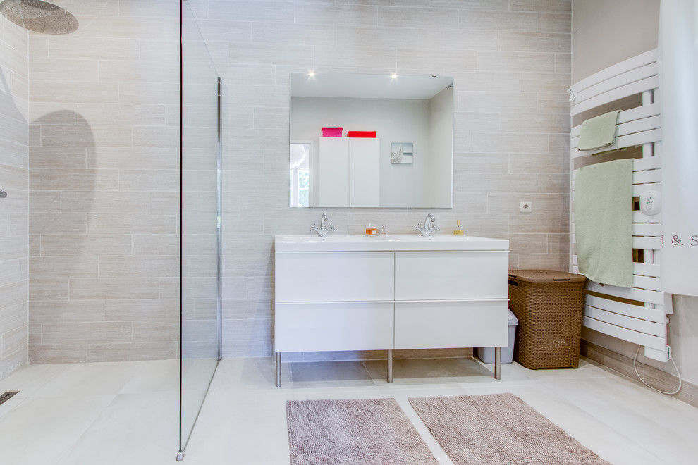 Diseño de cuarto de baño contemporáneo de tamaño medio con armarios con paneles lisos, puertas de armario blancas, baldosas y/o azulejos beige, lavabo integrado, ducha a ras de suelo, paredes beige y aseo y ducha