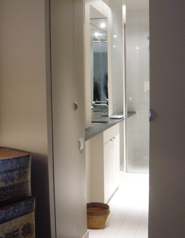 パリにあるお手頃価格の小さなコンテンポラリースタイルのおしゃれなバスルーム (浴槽なし) (インセット扉のキャビネット、白いキャビネット、分離型トイレ、白いタイル、磁器タイル、白い壁、セラミックタイルの床、アンダーカウンター洗面器、オープン型シャワー、白い床、開き戸のシャワー) の写真