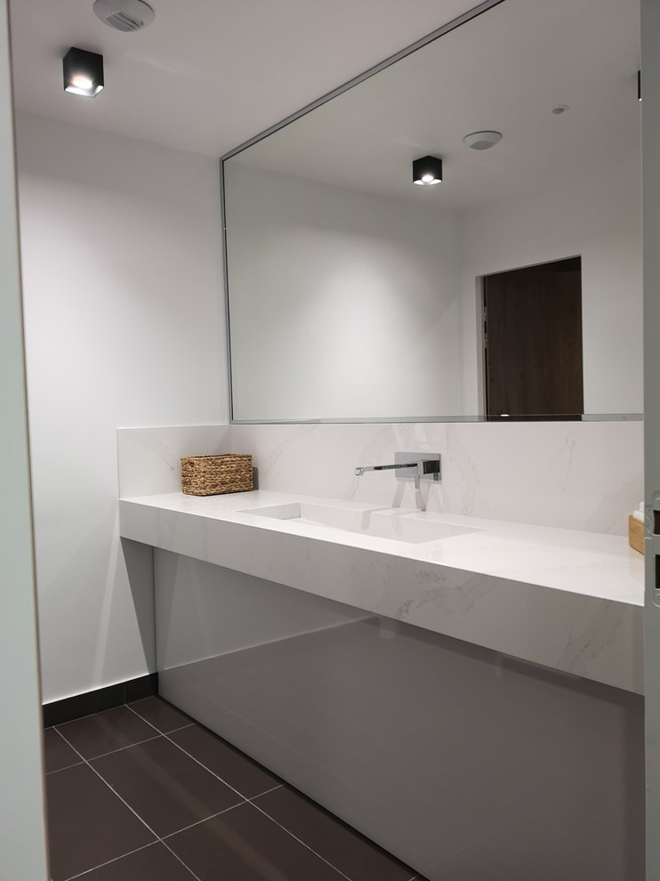 Modernes Badezimmer mit Quarzit-Waschtisch und weißer Waschtischplatte in Paris