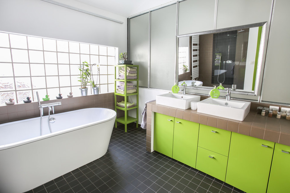 Idéer för ett stort modernt grå en-suite badrum, med luckor med profilerade fronter, gröna skåp, ett platsbyggt badkar, en kantlös dusch, en vägghängd toalettstol, svart kakel, keramikplattor, vita väggar, klinkergolv i keramik, ett fristående handfat, kaklad bänkskiva, svart golv och med dusch som är öppen