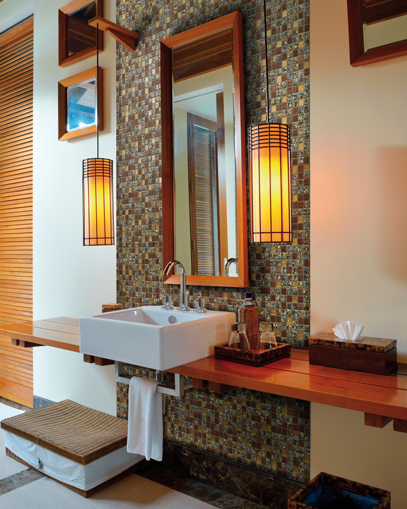 Réalisation d'une salle de bain design avec un lavabo suspendu et un plan de toilette en bois.
