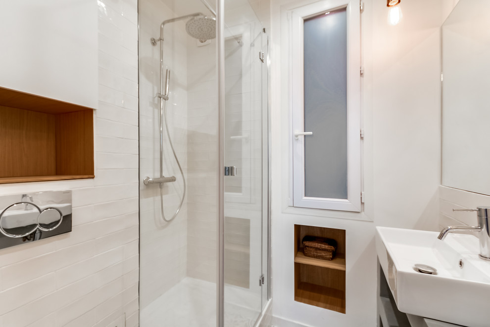Modern inredning av ett litet en-suite badrum, med en kantlös dusch, en vägghängd toalettstol, blå kakel, stickkakel, vita väggar, klinkergolv i keramik, ett nedsänkt handfat och bänkskiva i betong