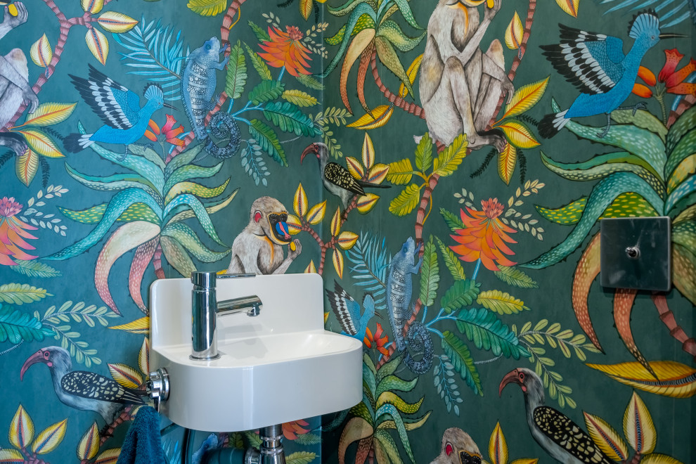Cette image montre un WC et toilettes ethnique de taille moyenne avec un mur multicolore, un lavabo suspendu et du papier peint.
