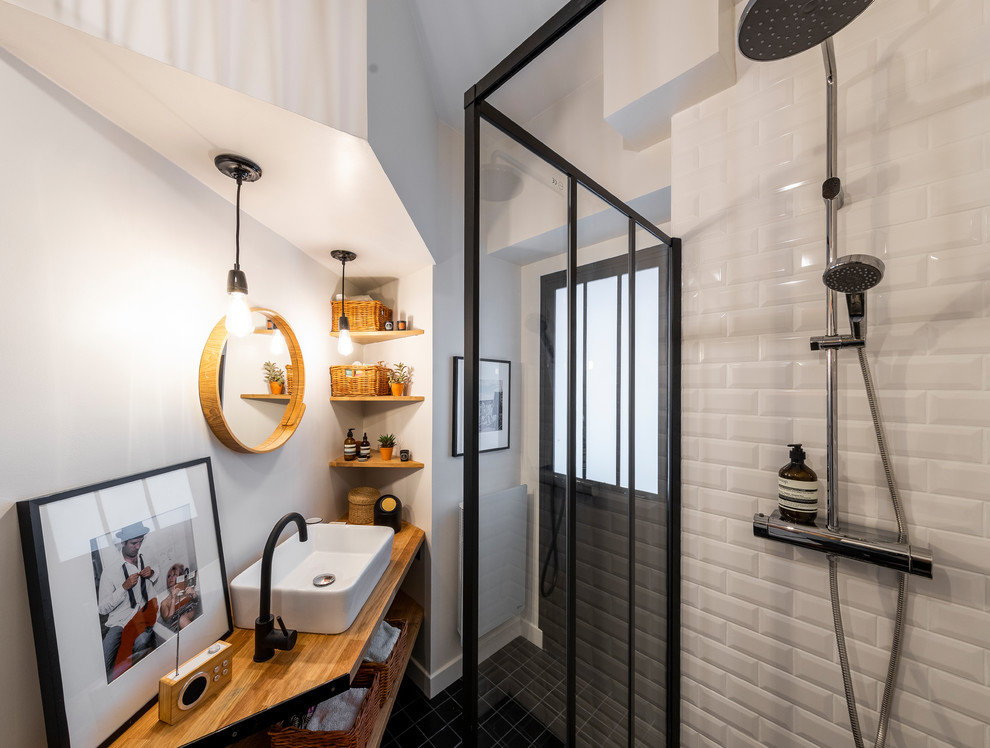 Example of a small trendy master subway tile cement tile floor and black floor walk-in shower design in Paris with a wall-mount toilet, white walls, a drop-in sink and wood countertops