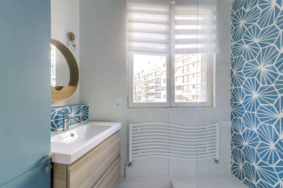 Trendy 3/4 blue tile and cement tile ceramic tile doorless shower photo in Paris with beaded inset cabinets, blue cabinets, white walls and a console sink