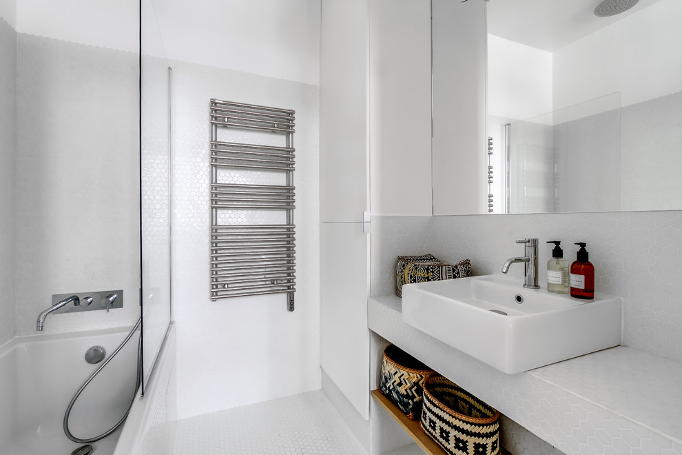 Modern inredning av ett mellanstort en-suite badrum, med ett fristående handfat, kaklad bänkskiva, ett badkar i en alkov, en dusch/badkar-kombination, vit kakel, mosaik, mosaikgolv, vita skåp och vita väggar