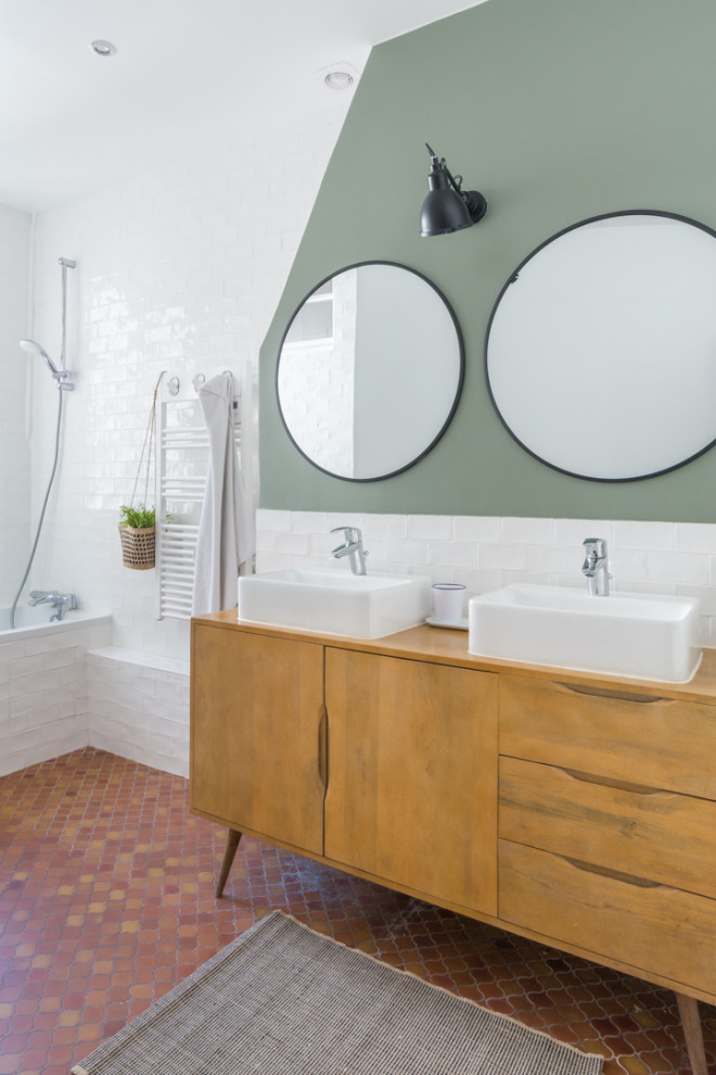 This is an example of a contemporary bathroom in Paris with medium wood cabinets, white tiles, grey walls, terracotta flooring, a vessel sink, wooden worktops, red floors and flat-panel cabinets.