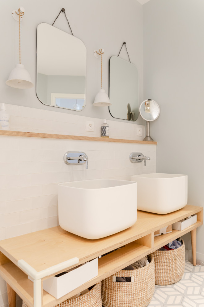 Inredning av ett minimalistiskt stort beige beige en-suite badrum, med öppna hyllor, skåp i ljust trä, ett fristående badkar, en dusch/badkar-kombination, vit kakel, perrakottakakel, grå väggar, cementgolv, ett fristående handfat, träbänkskiva, grått golv och med dusch som är öppen