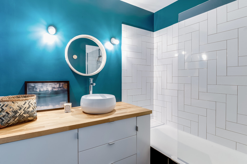 Esempio di una stanza da bagno padronale scandinava con WC a due pezzi, piastrelle bianche, pareti blu, top in legno, lavabo a bacinella e top marrone