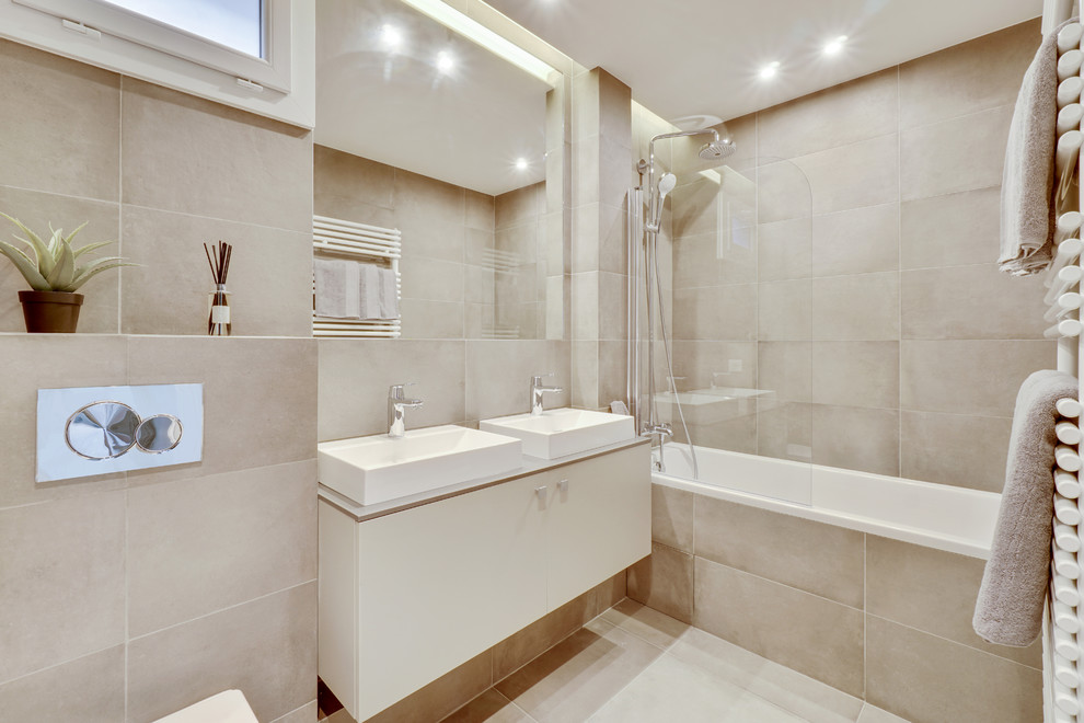 Aménagement d'une salle d'eau contemporaine de taille moyenne avec un placard à porte affleurante, des portes de placard grises, une baignoire encastrée, un combiné douche/baignoire, WC suspendus, un carrelage gris, des carreaux de céramique, un mur gris, un sol en carrelage de céramique, un lavabo encastré, un plan de toilette en quartz, un sol gris et un plan de toilette gris.
