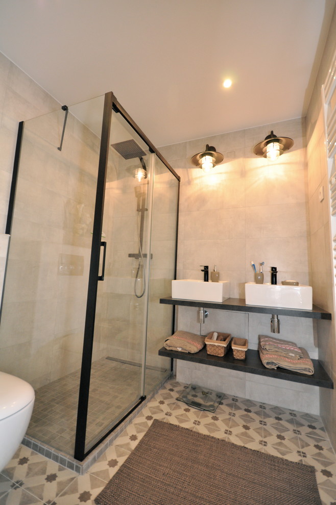 Cette image montre une petite salle de bain principale urbaine avec une douche à l'italienne, un carrelage beige, des carreaux de céramique, un mur beige, carreaux de ciment au sol, un lavabo posé, un plan de toilette en carrelage, un sol beige, une cabine de douche à porte coulissante et WC suspendus.