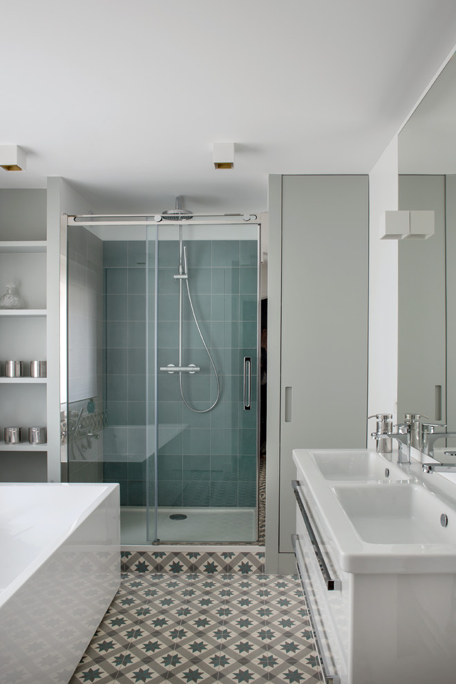 На фото: главная ванная комната среднего размера в современном стиле с белыми стенами, полом из керамической плитки, белой плиткой, синей плиткой, керамогранитной плиткой, раковиной с несколькими смесителями, синим полом, душем с раздвижными дверями, душем в нише и отдельно стоящей ванной с