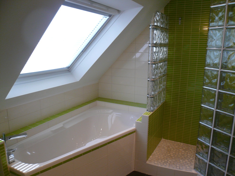 Exemple d'une salle de bain principale moderne de taille moyenne avec une baignoire d'angle, une douche ouverte, un carrelage vert, des carreaux de céramique, un mur vert, un sol en ardoise, un lavabo intégré et un plan de toilette en surface solide.