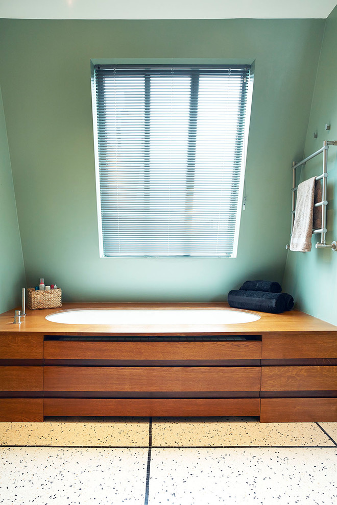 Cette photo montre une salle de bain principale tendance de taille moyenne avec une baignoire encastrée, un mur vert et du carrelage bicolore.