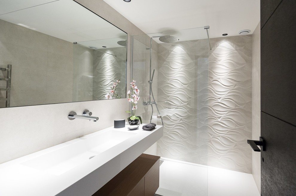 Inredning av ett modernt mellanstort badrum med dusch, med en kantlös dusch, en toalettstol med separat cisternkåpa, vit kakel, cementkakel, vita väggar, ett undermonterad handfat, bänkskiva i rostfritt stål och med dusch som är öppen