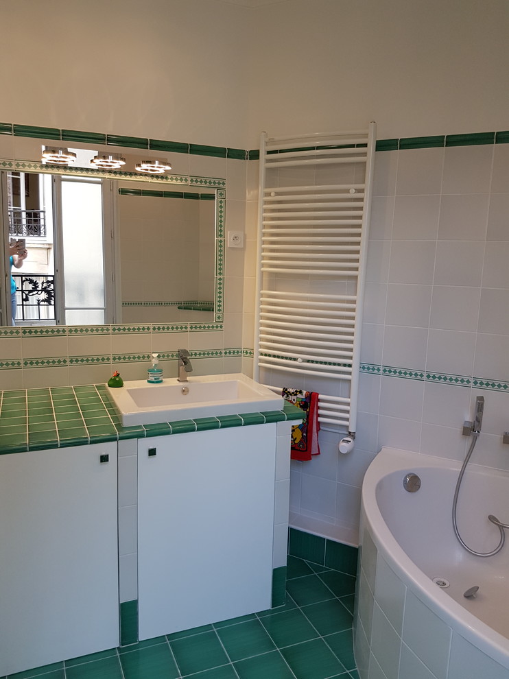 На фото: большая ванная комната в стиле неоклассика (современная классика) с плоскими фасадами, белыми фасадами, угловой ванной, душем в нише, биде, зеленой плиткой, керамогранитной плиткой, белыми стенами, полом из керамической плитки, душевой кабиной, накладной раковиной, столешницей из плитки, зеленым полом, душем с распашными дверями и бирюзовой столешницей